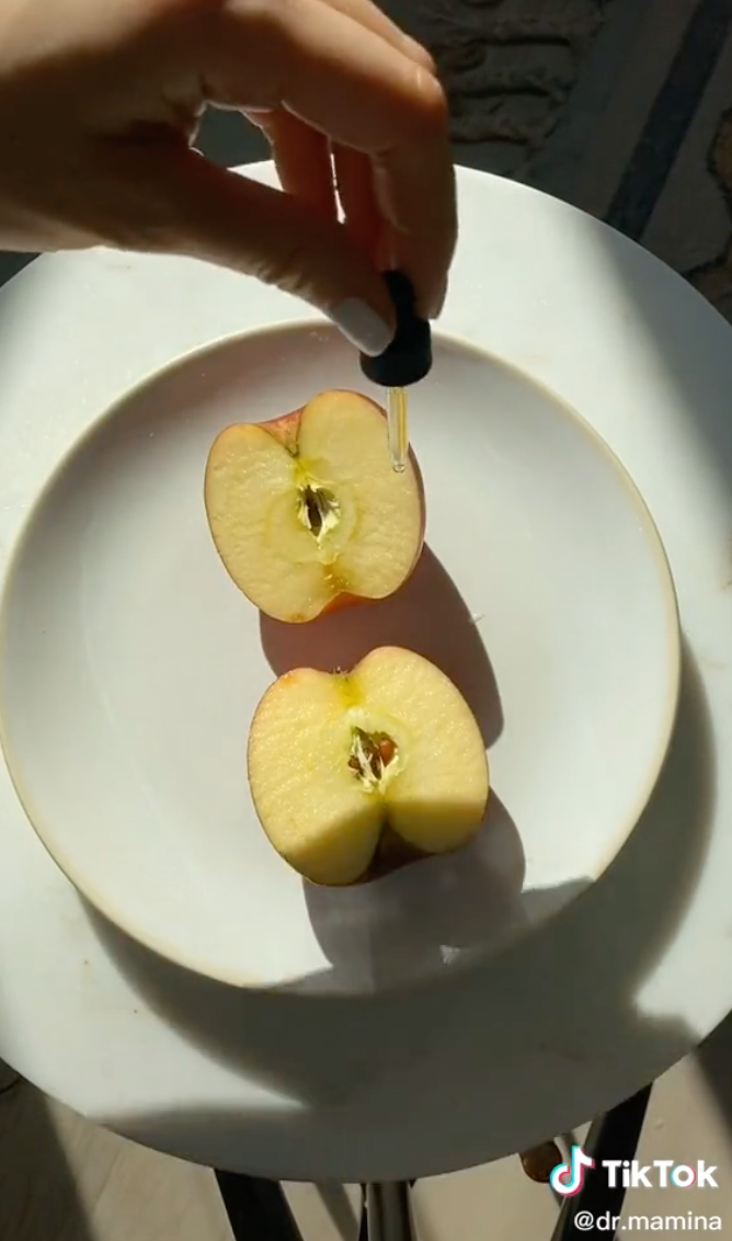 doctor applying serum to an apple half