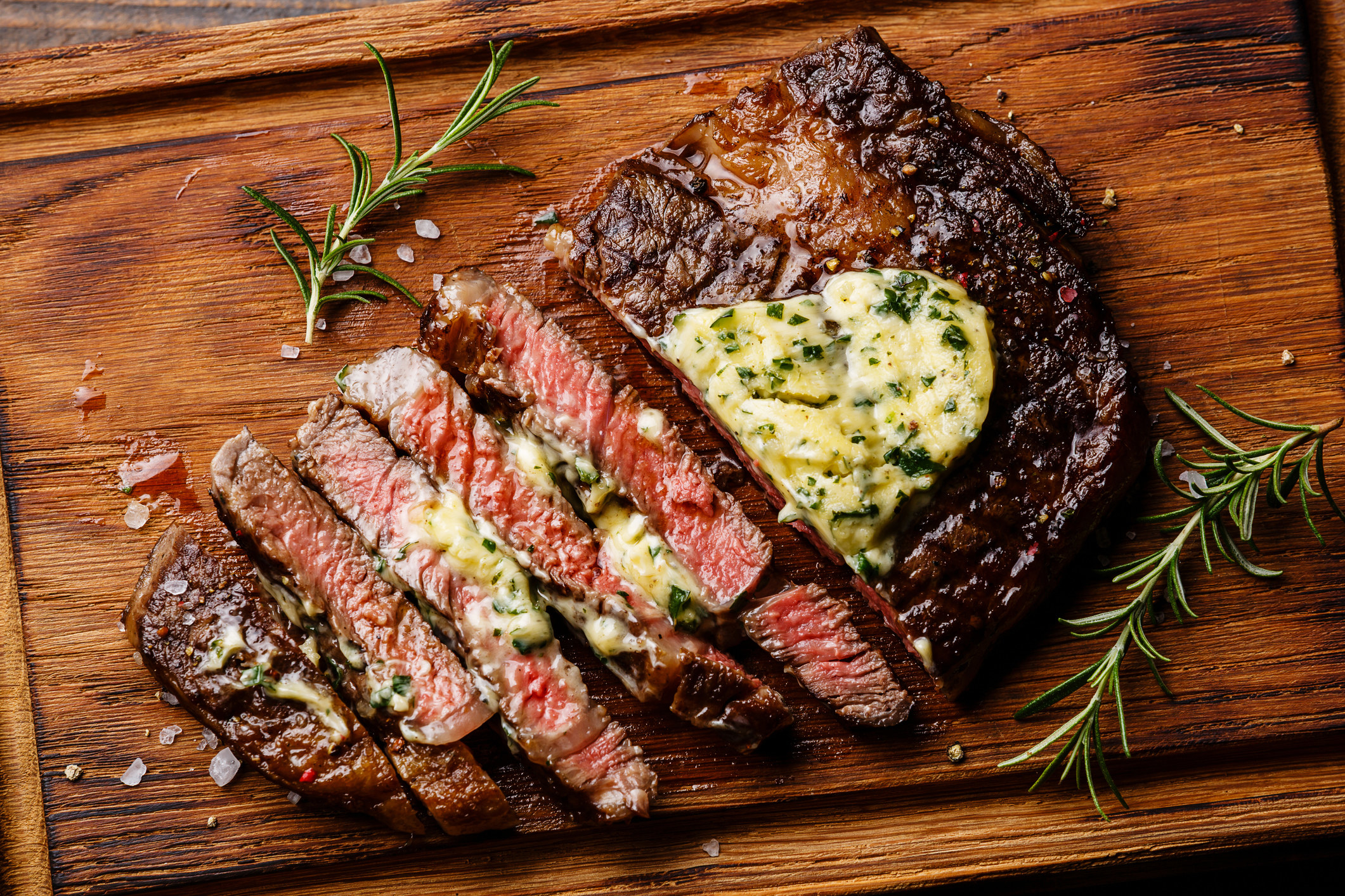 A ribeye steak topped with herb butter.