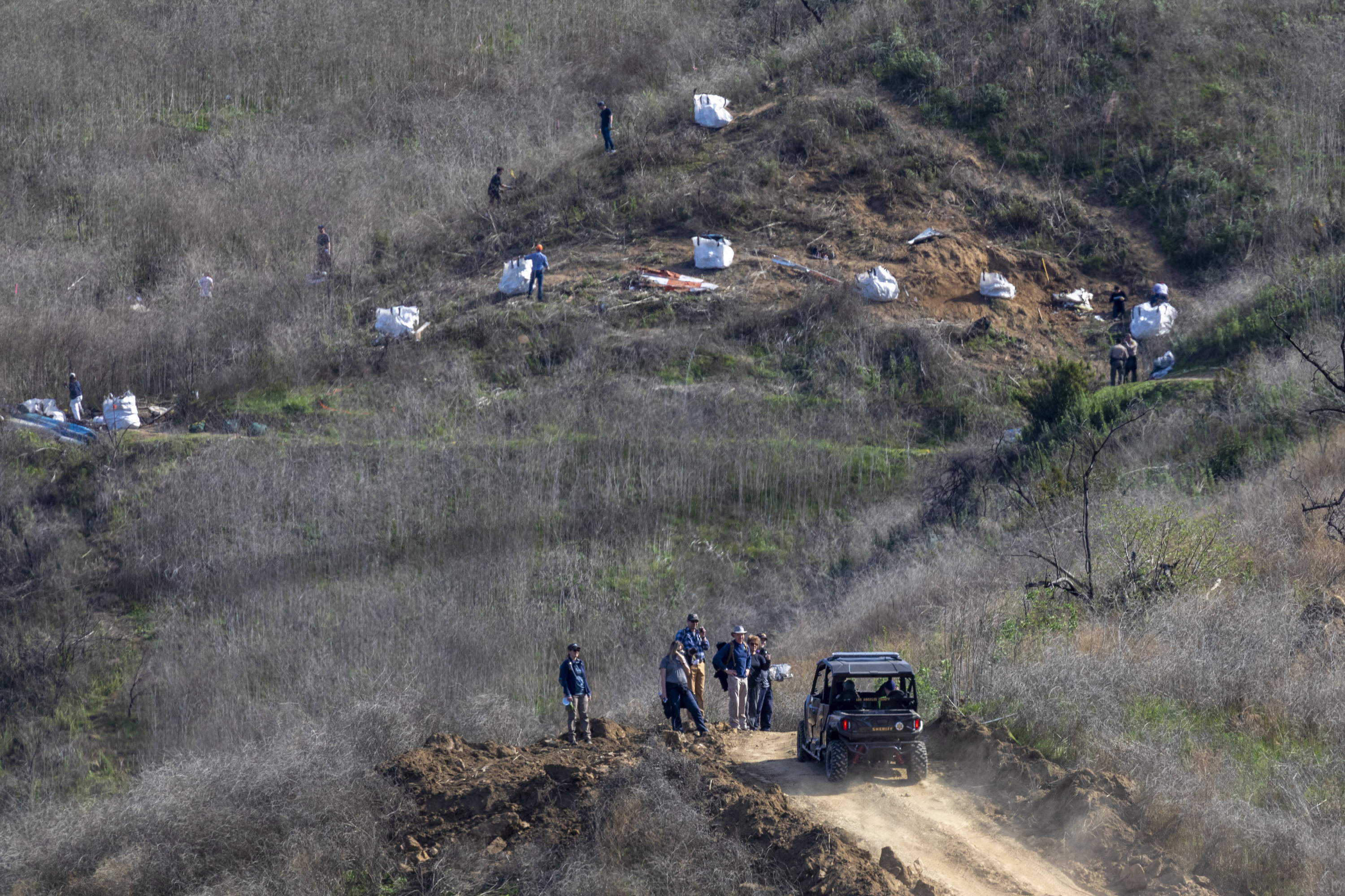 Investigators work at the scene of the helicopter crash