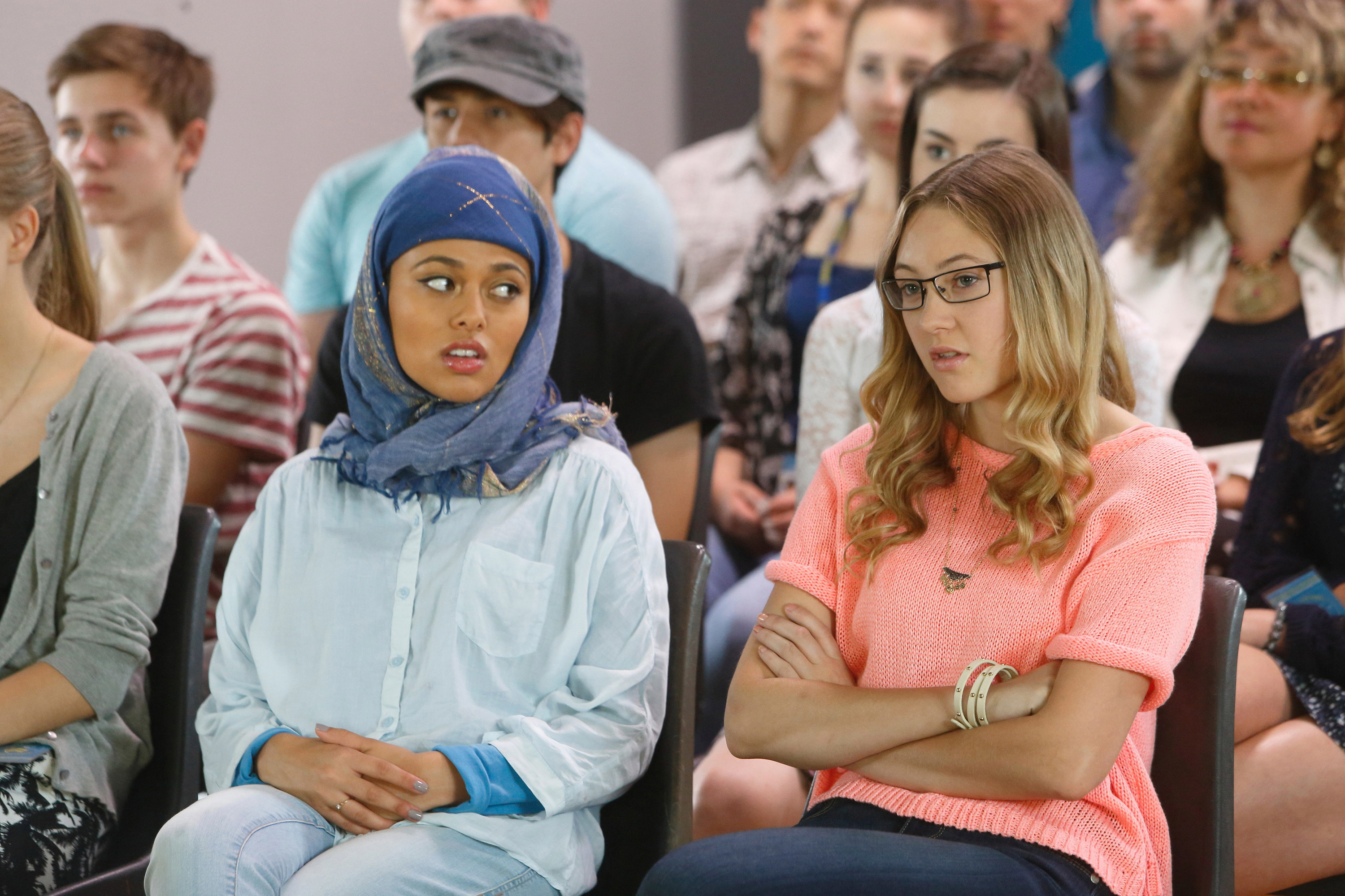 Two girls sitting in a crowd