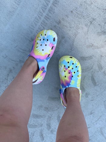 reviewer wearing pastel swirl tie-dye crocs