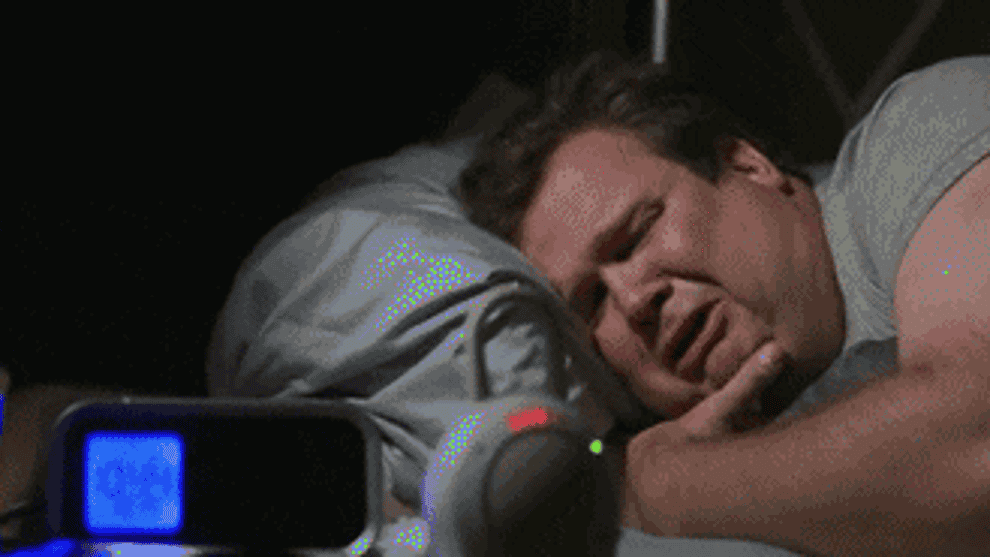 gif of modern family character cam crying while listening to baby monitor in bed