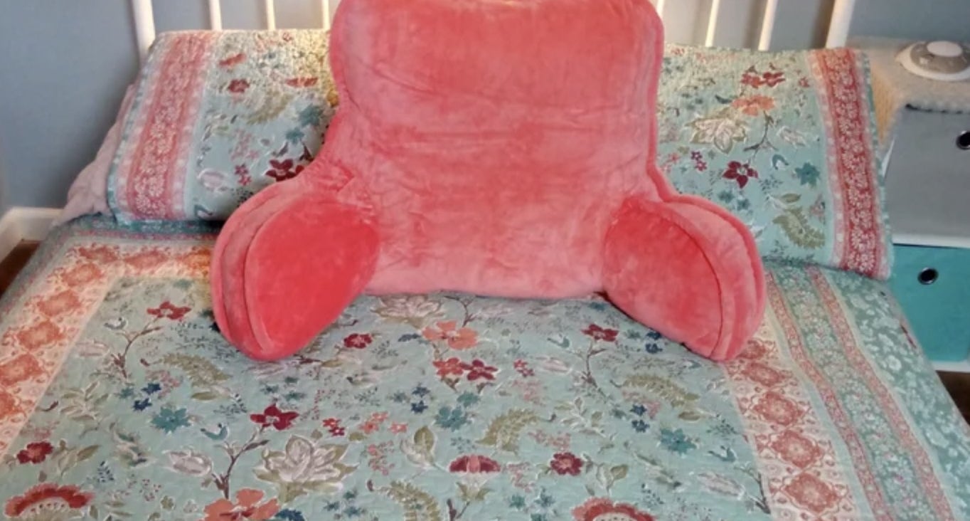 Reviewer&#x27;s photo of the pink pillow resting on bed