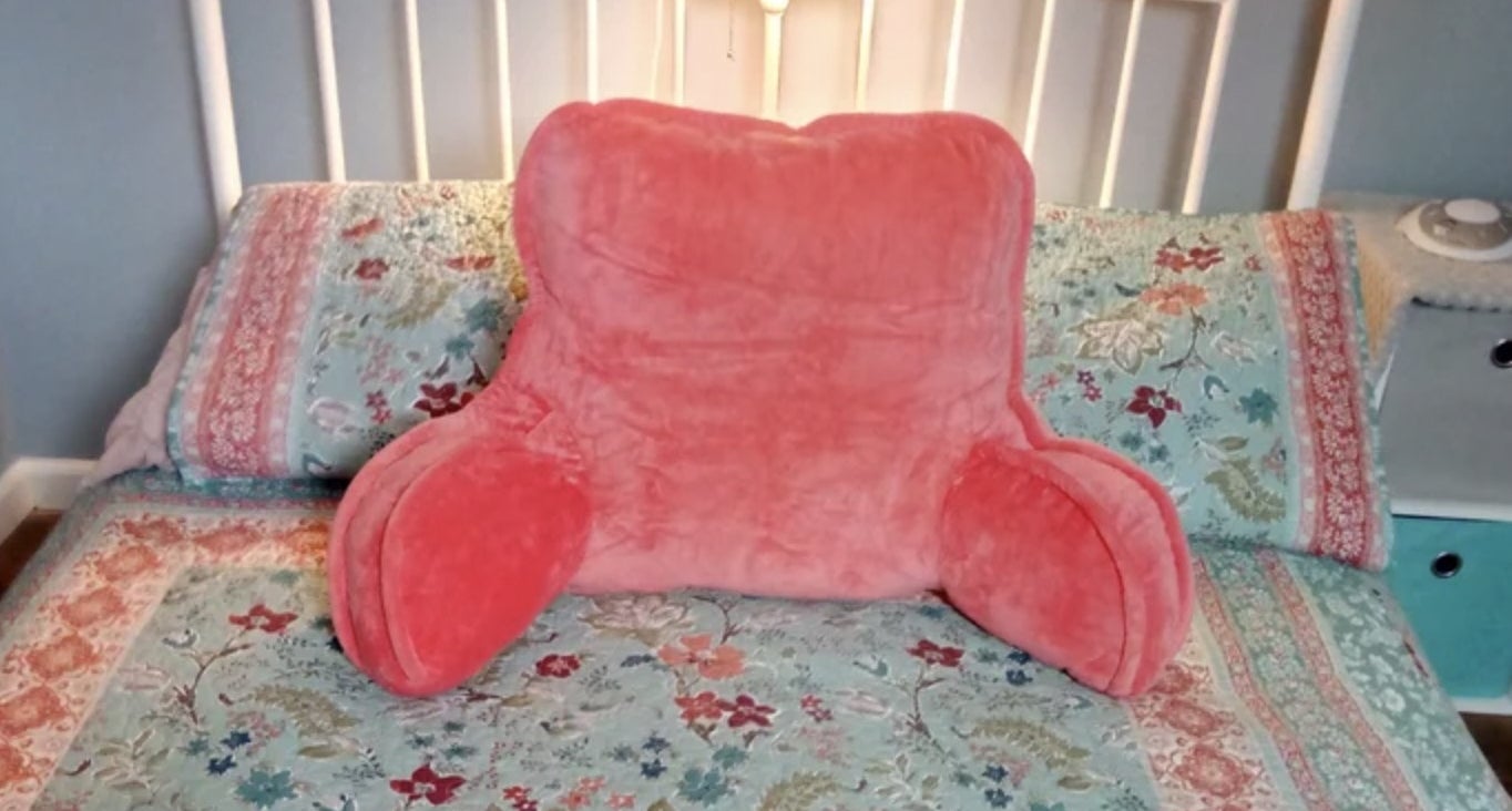 Reviewer&#x27;s photo of the pink pillow resting on bed