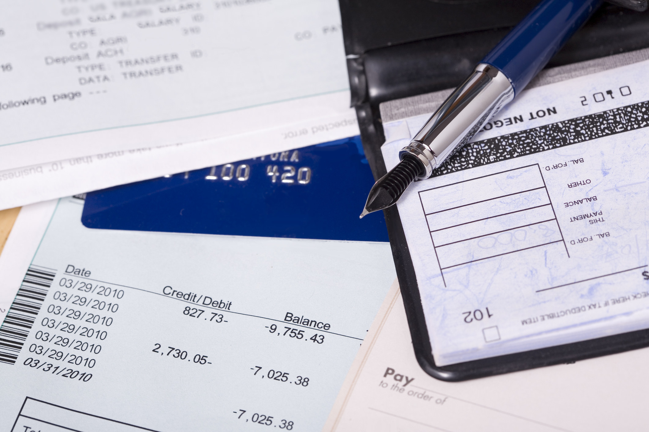 A checkbook sits next to a credit card and a billing statement