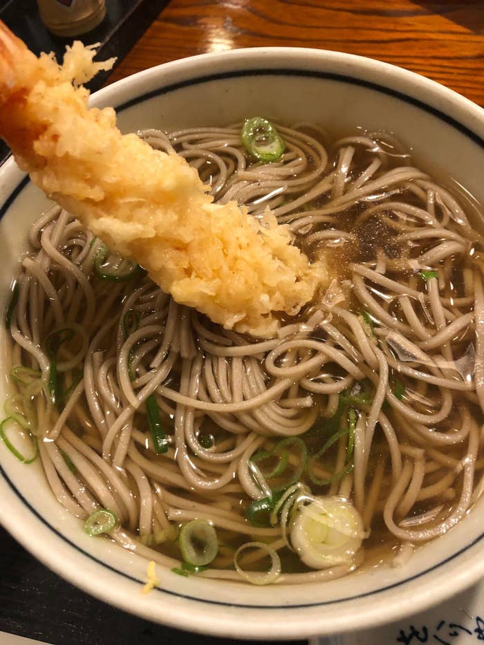 A bowl of soba with tempura shrimp.