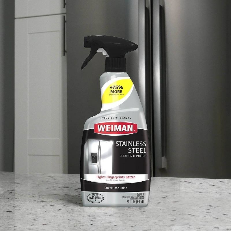 the spray bottle in front of a stainless steel refrigerator