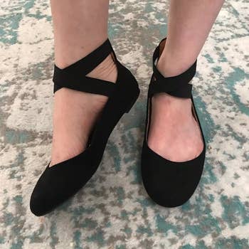 reviewer wearing black cross-strap ballerina flats