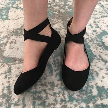 reviewer wearing black cross-strap ballerina flats