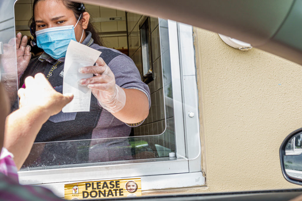 A drive-thru worker giving a receipt