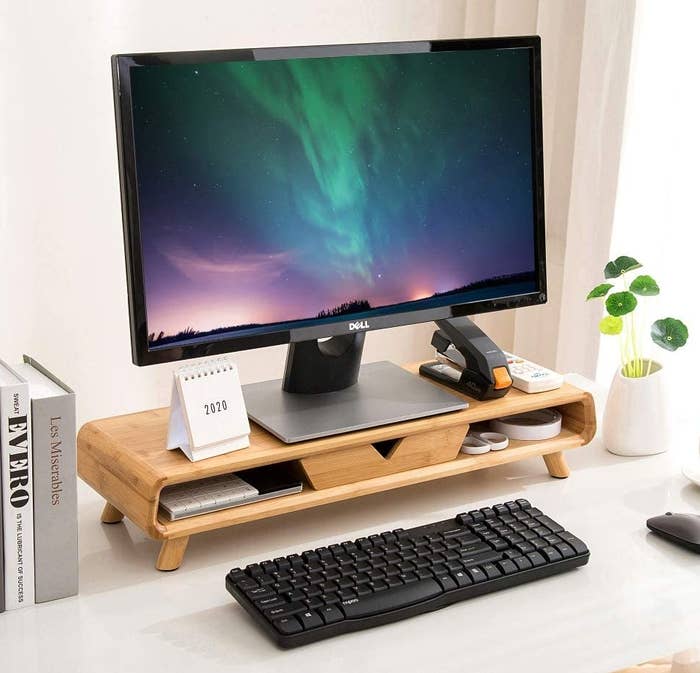 The monitor riser with a monitor on it on a desk