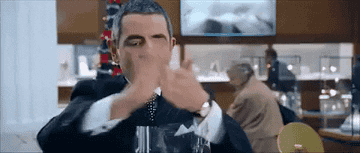 a gif of rowan atkinson from love actually smelling his hands with enthusiasm