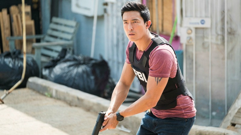 Daniel holding a gun and wearing an FBI bullet-proof vest in a scene from the film