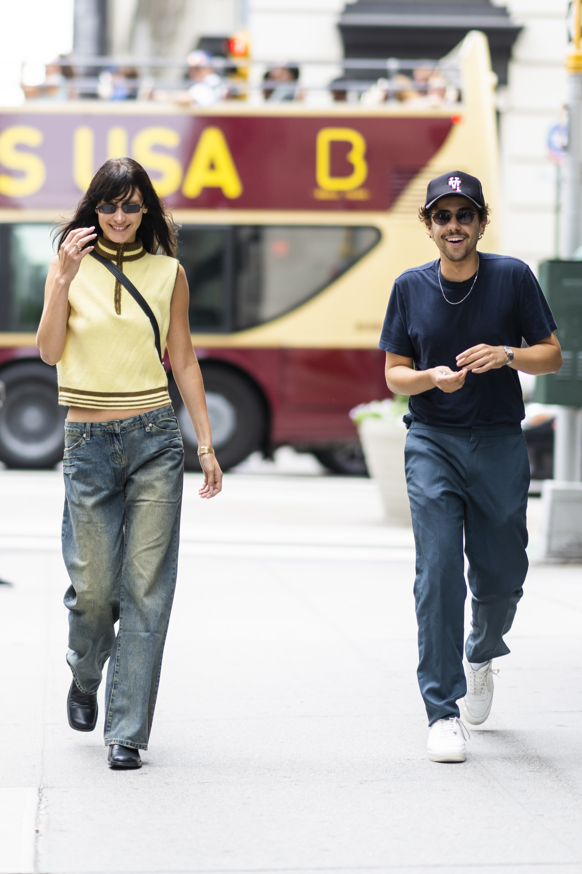 Bella Hadid and Ramy Youssef laugh as they walk down the street
