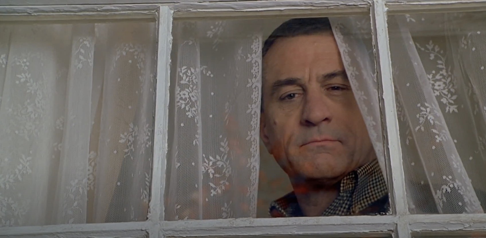 Robert De Niro peers out a window