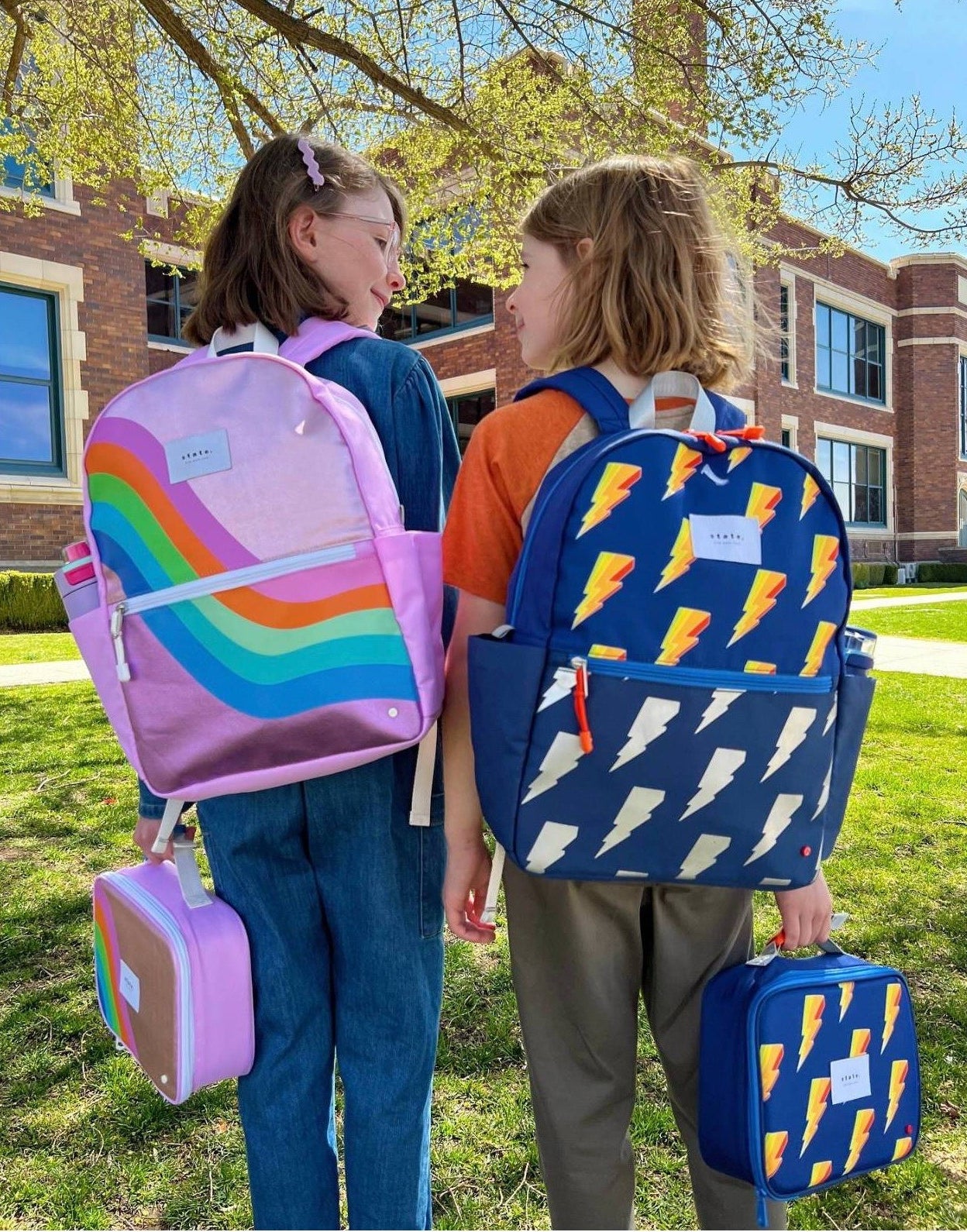 two kids wearing the backpacks at school