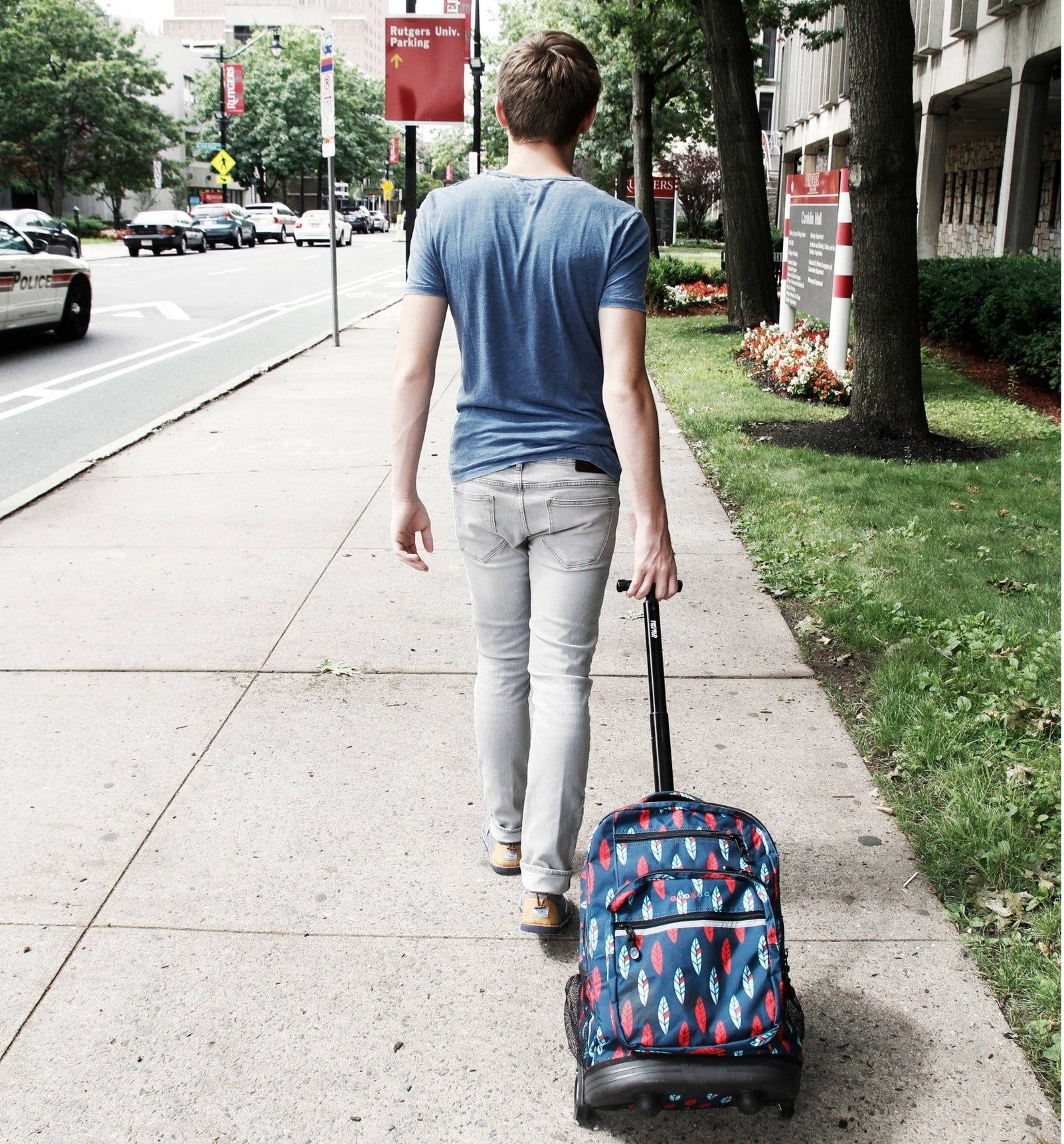 a model rolling the backpack down the sidewalk
