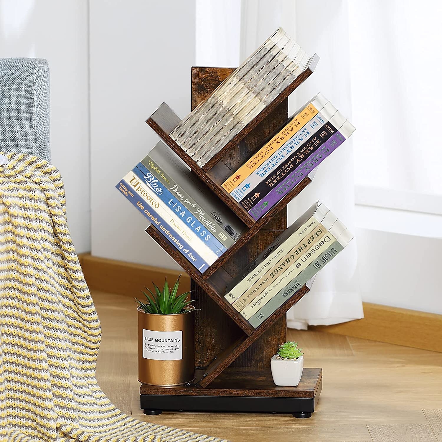 The bookshelf on the floor with books and plants on it
