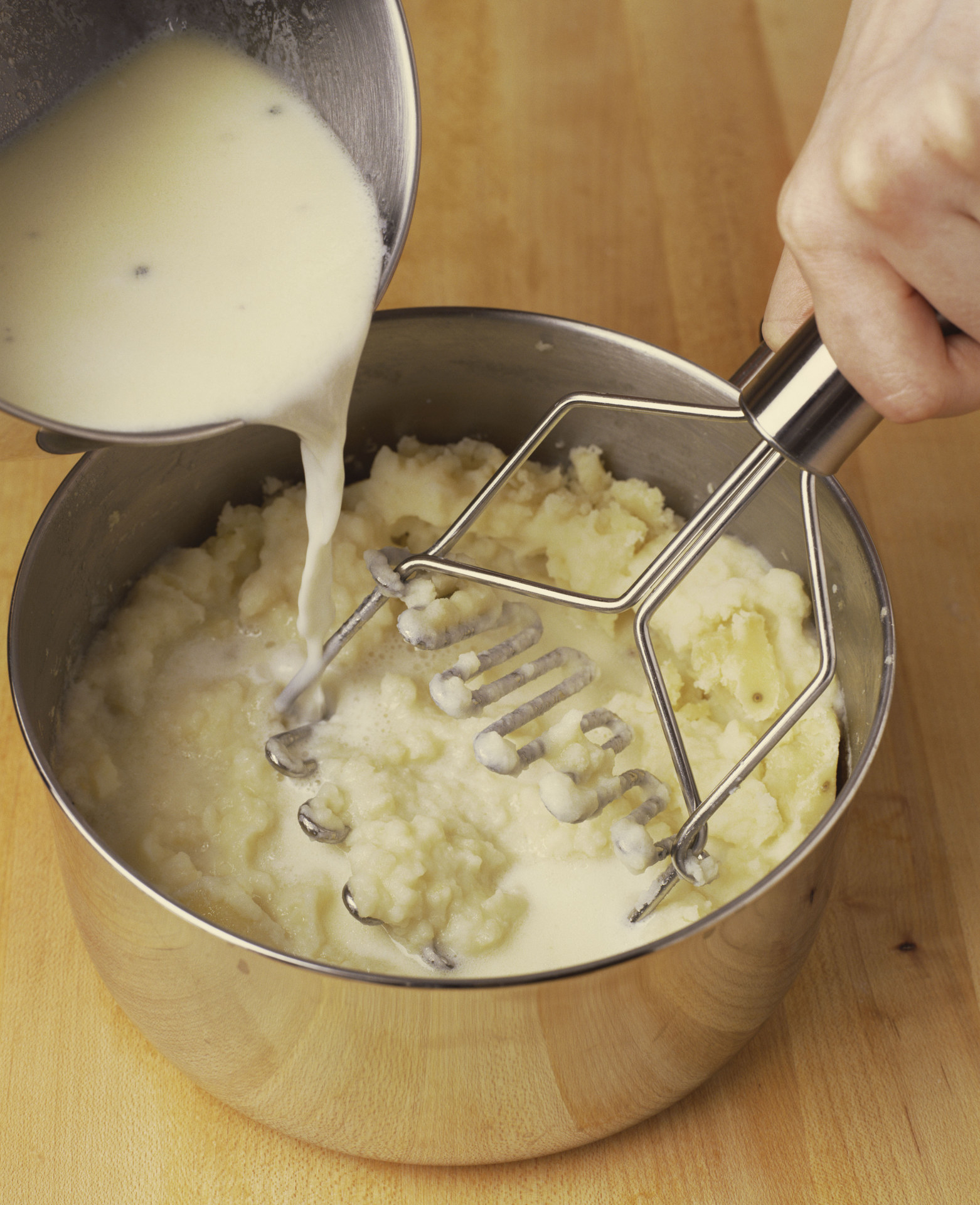 Someone making mashed potatoes