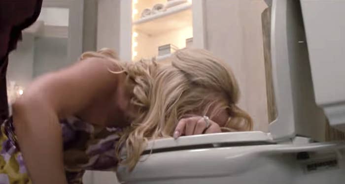 Woman vomits in toilet