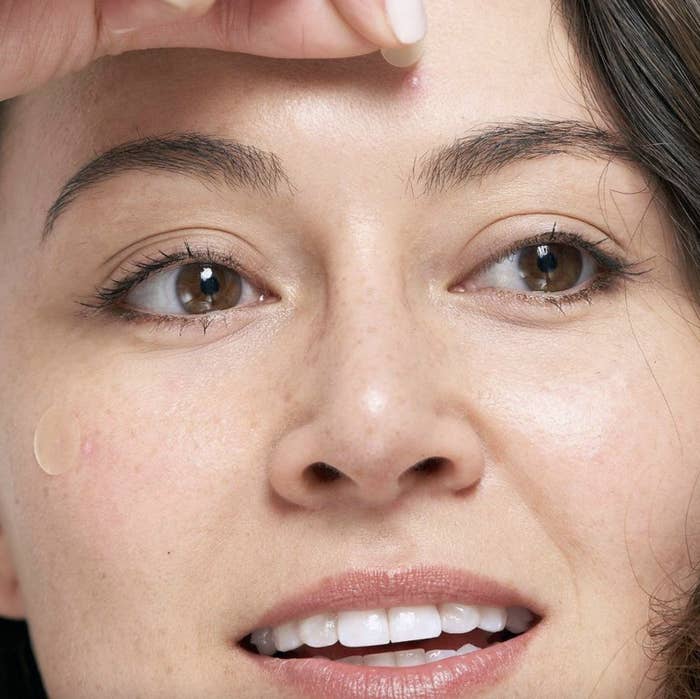 A person applying pimple patches