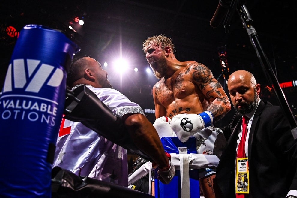 Jake Paul, bearded and shirtless, wails in celebration in a boxing ring after defeating some guy