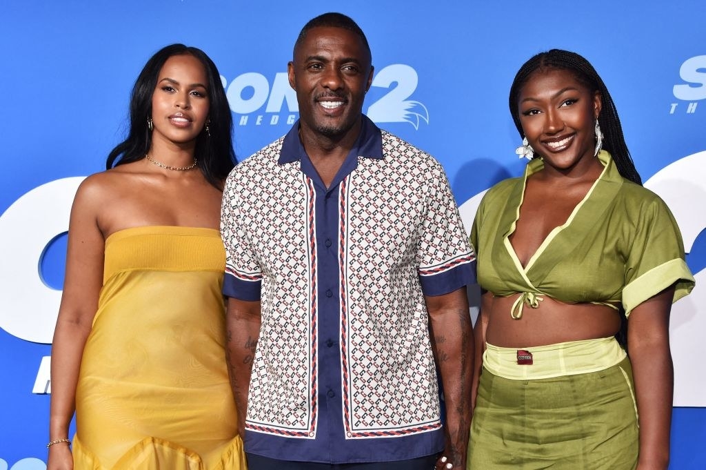 Idris smiles for photographers on the red carpet as he&#x27;s flanked by his wife and daughter