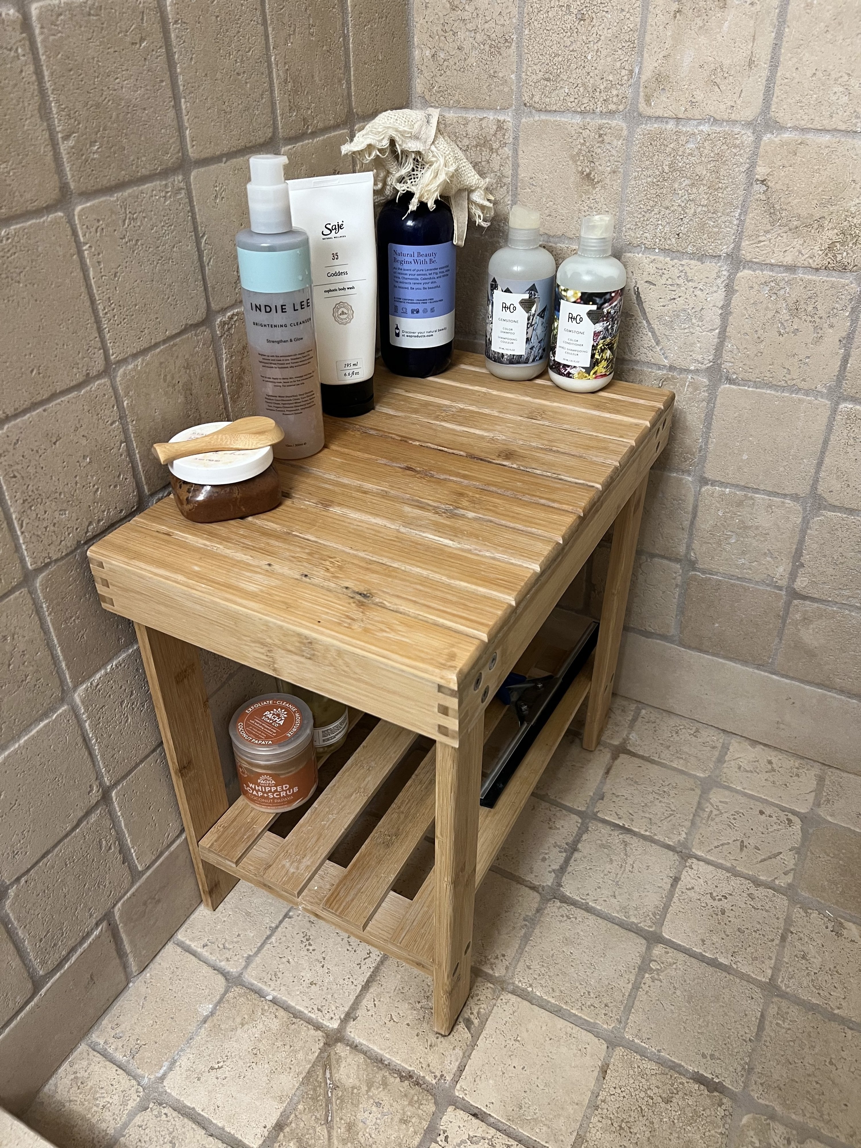 A bamboo shower stool is shown in a shower enclosure