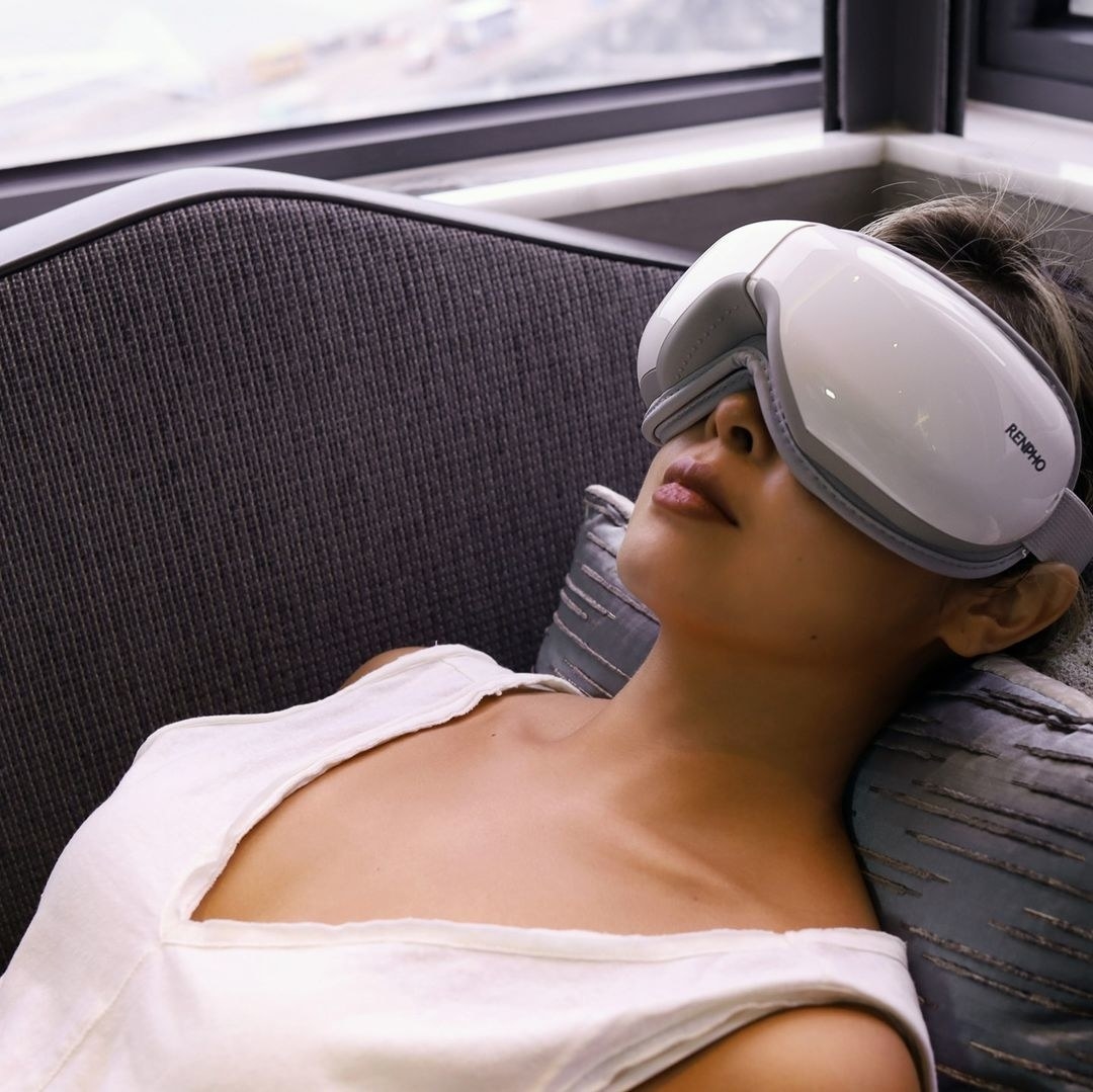 a person wearing the eye massager while lying down