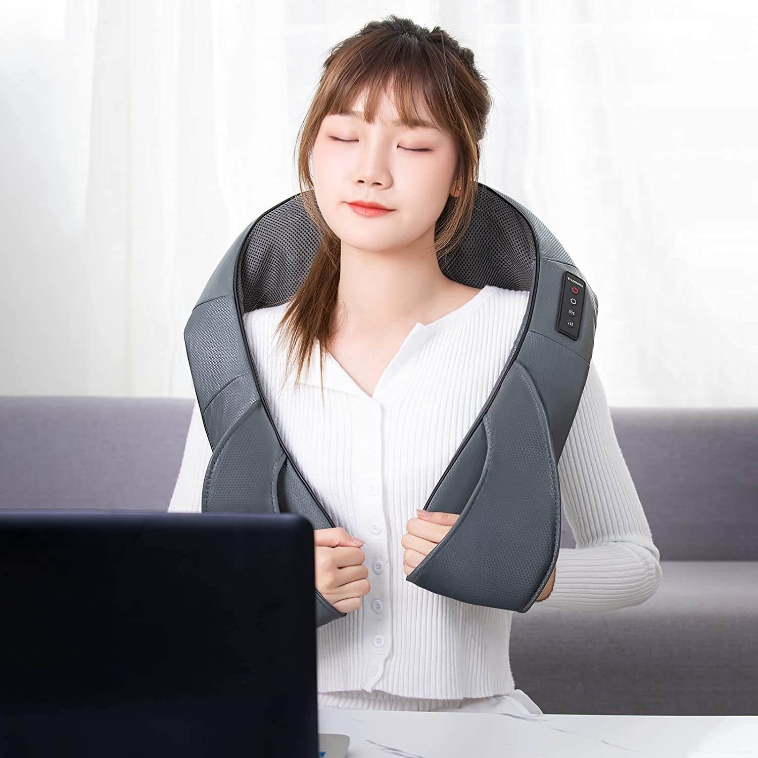 a person wearing the massage device around their shoulders
