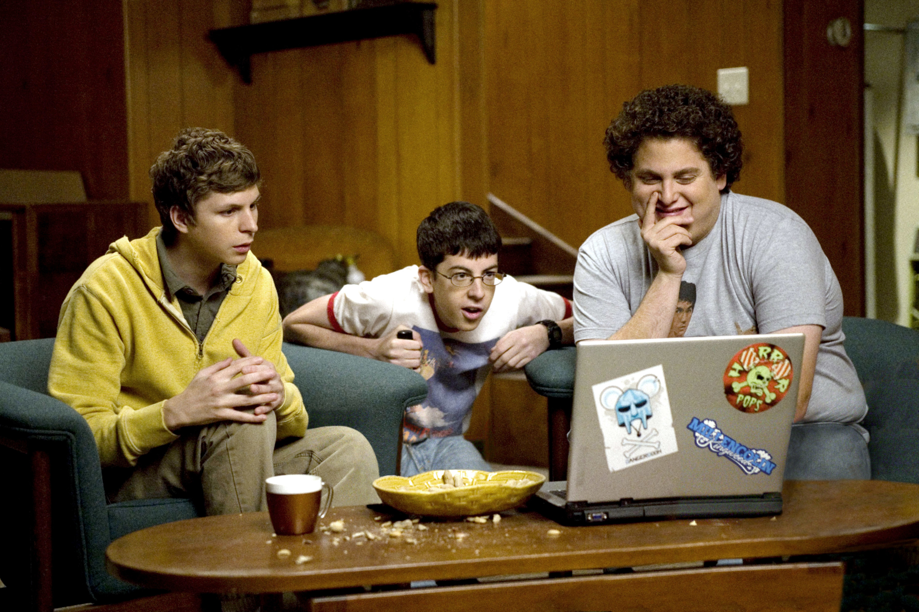 Jonah, Christopher and Michael look at a computer screen in the movie