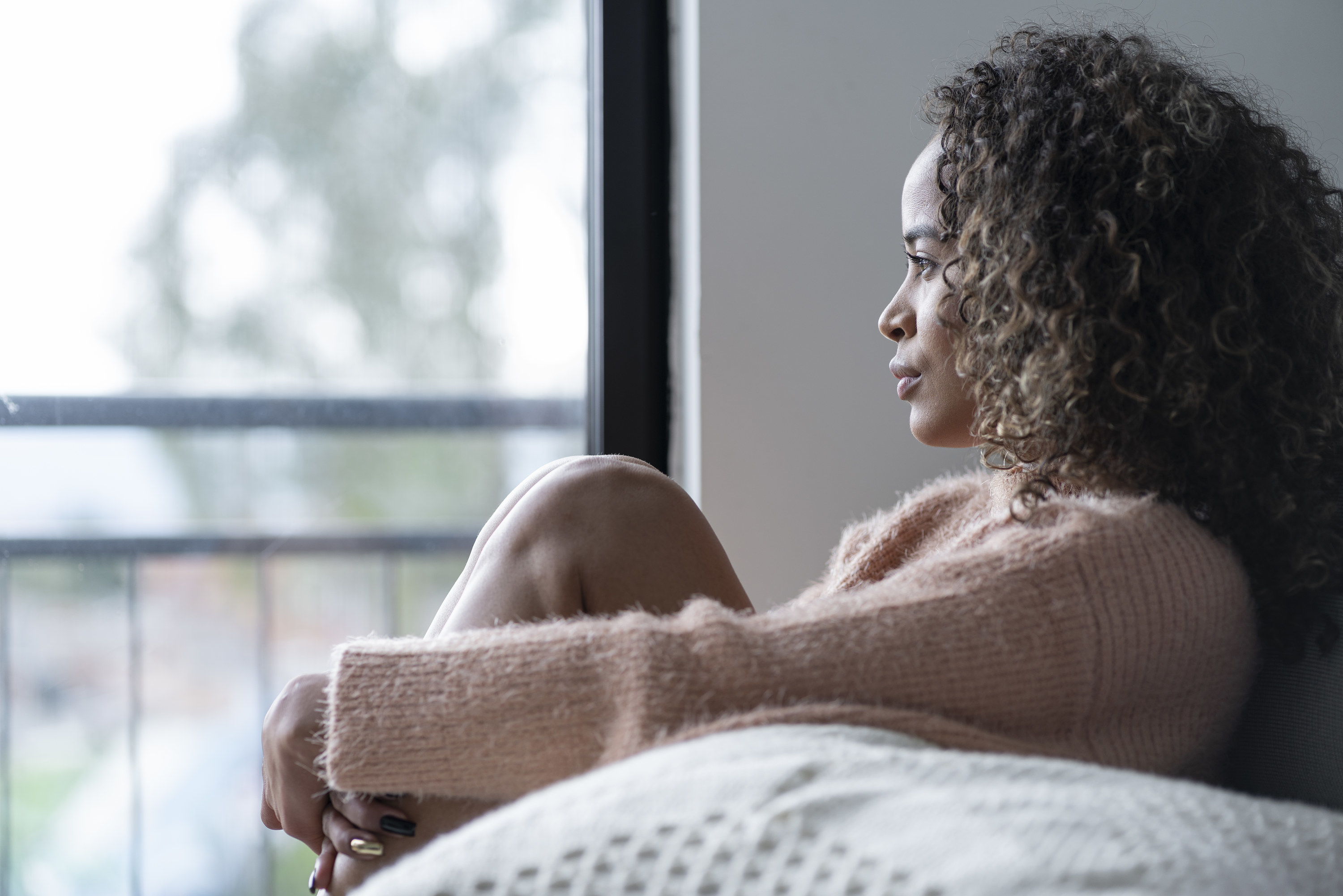 a woman looking sad staring out the window