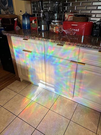 rainbows from the prismatic window film cast across a kitchen