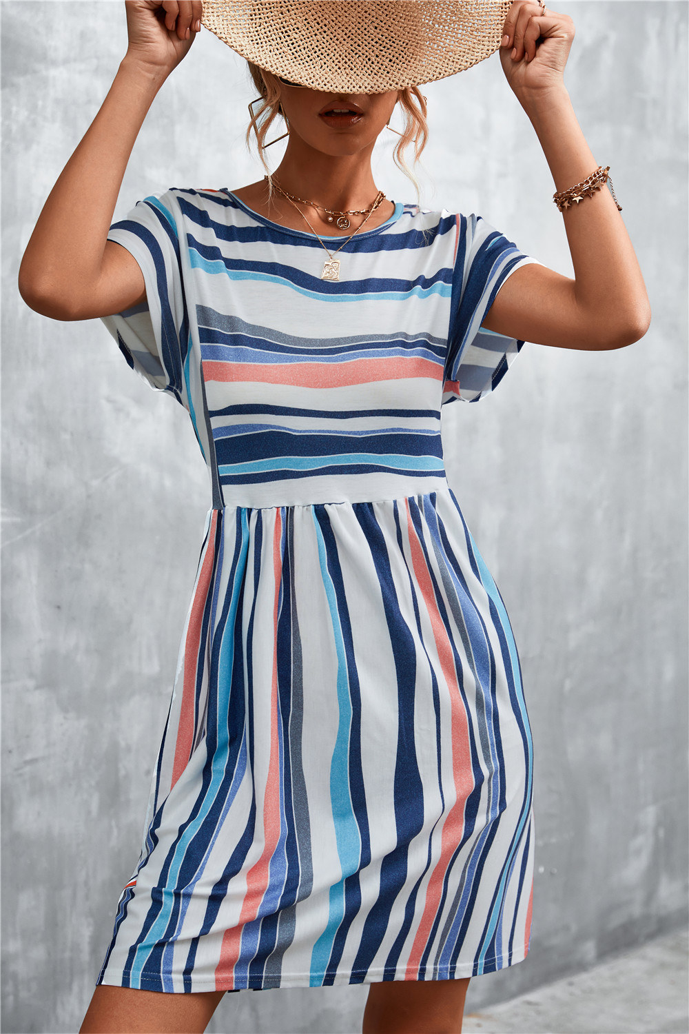 model wearing the pink, white, blue and gray striped dress