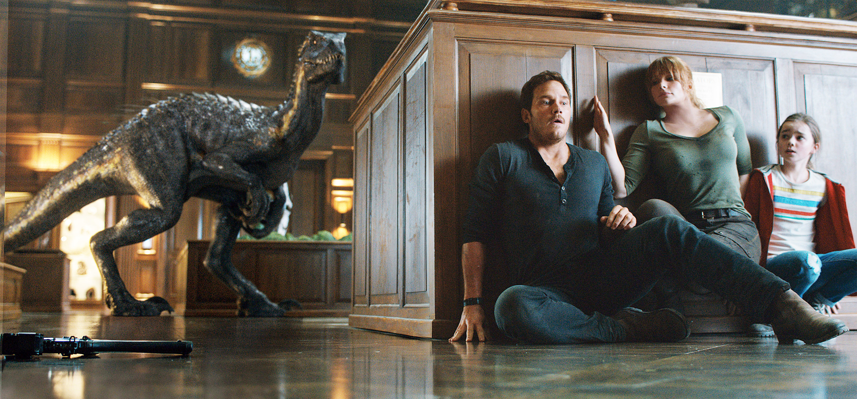 A dinosaur looks for Chris Pratt, Bryce Dallas Howard, and Isabella Sermon