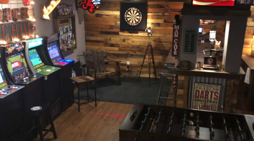 A man cave with a dart board and arcade games