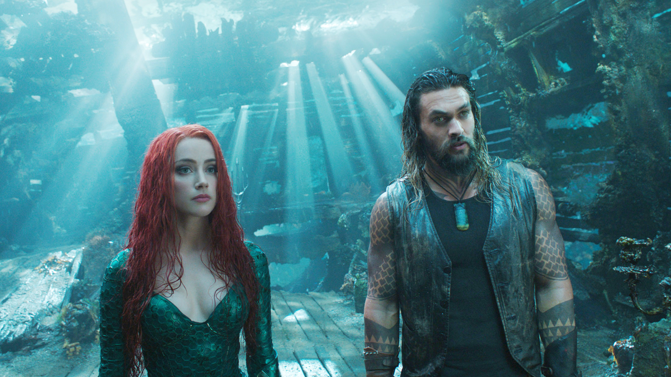Amber Heard and Jason Mamoa stand in a ruined ship