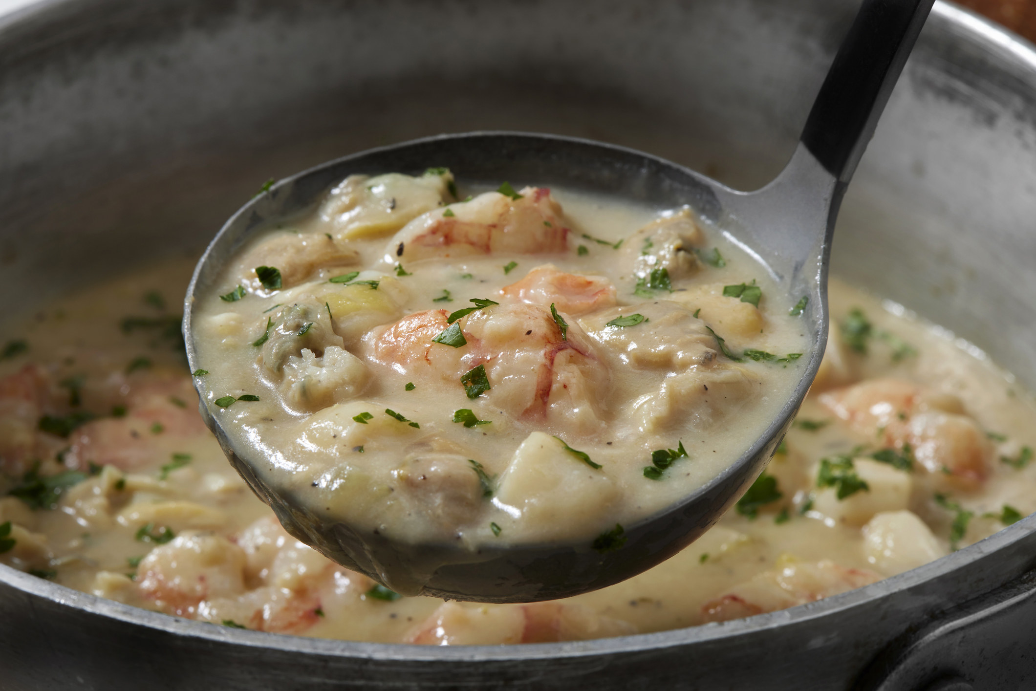 A ladle full of seafood chowder.