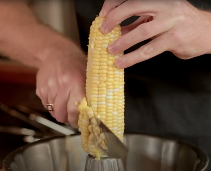 Someone slicing corn off the cob.