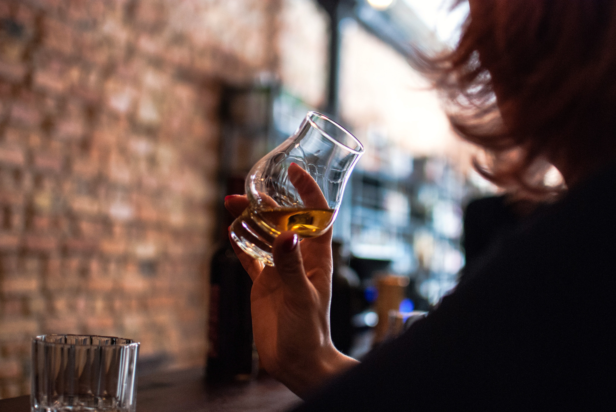 Person at a bar holding a glass