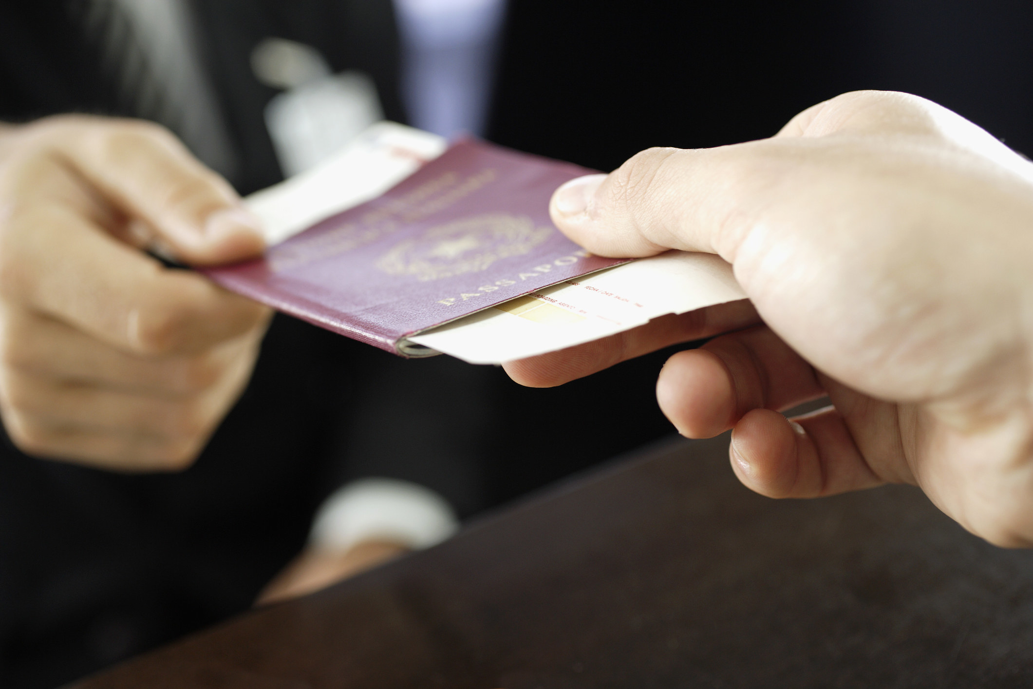 Person handing a passport to another person