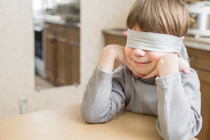 young boy blindfolded and smiling