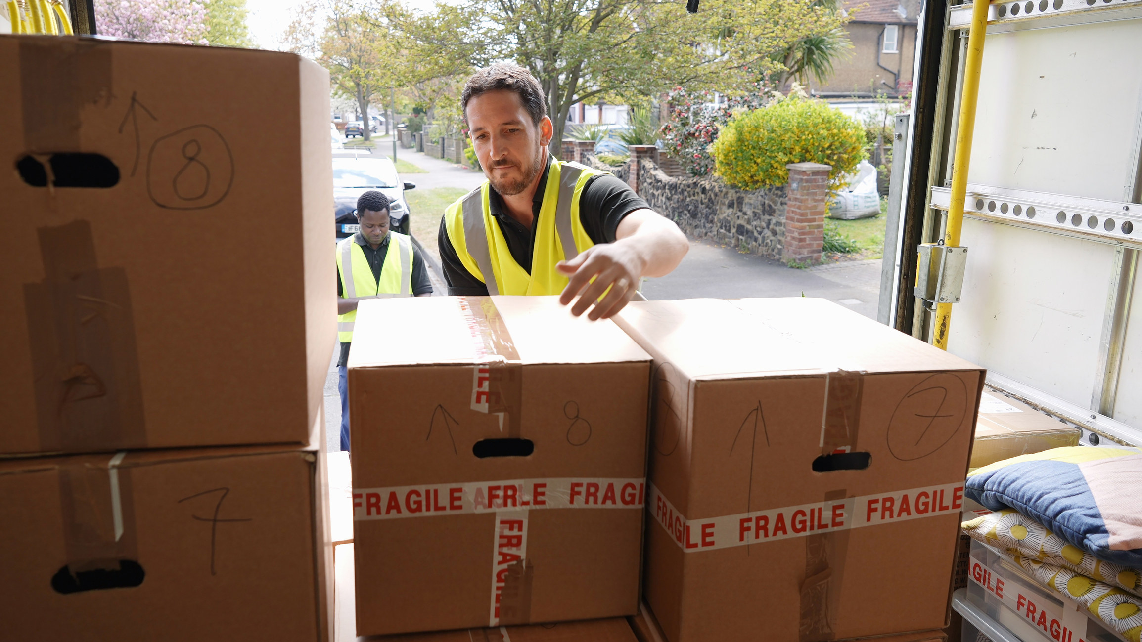 Men putting boxes in the back of a truck