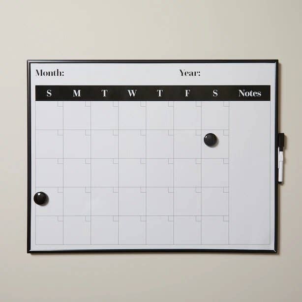 Dry-erase calendar board up against a plain wall