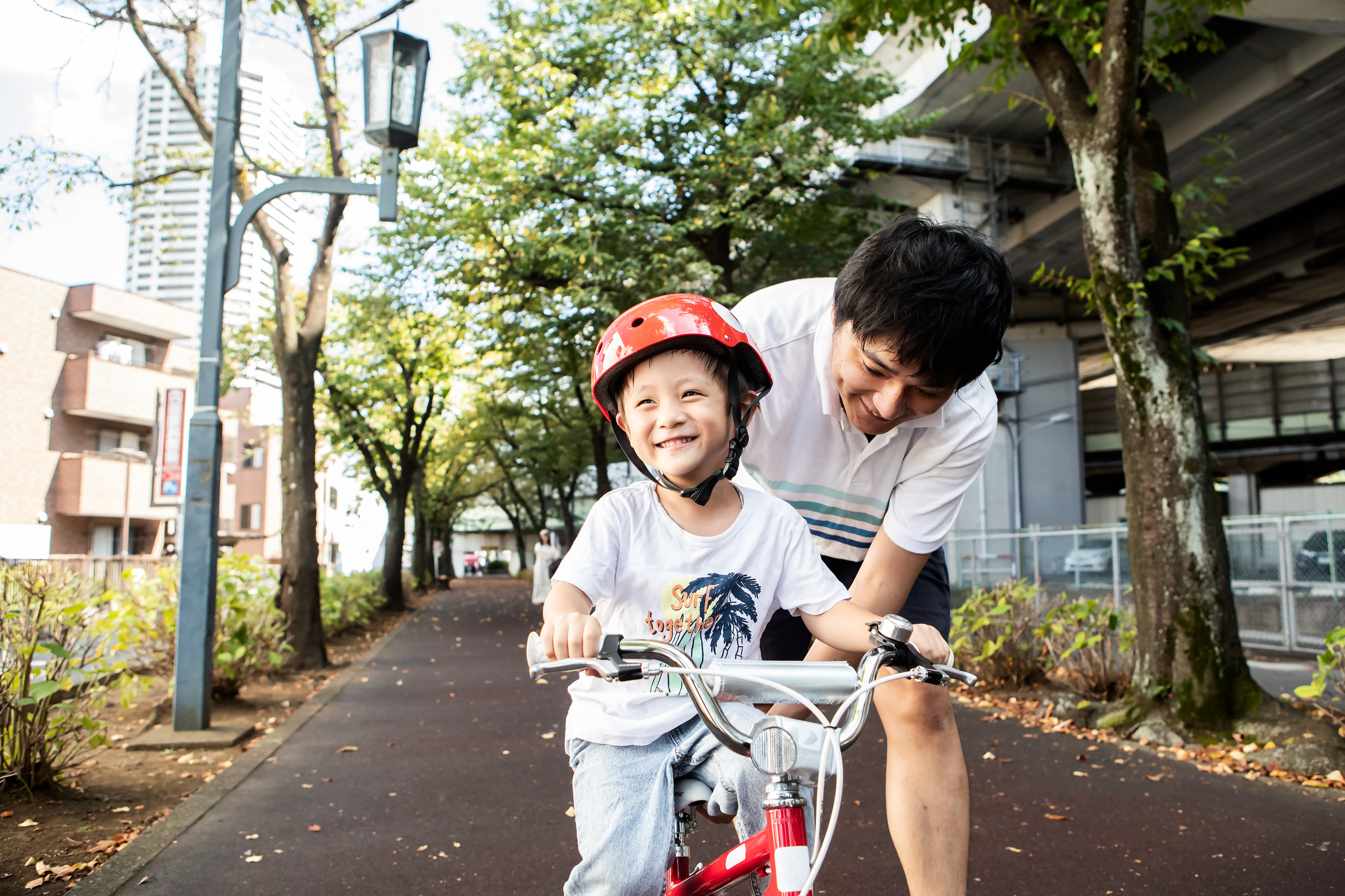 一个人帮助一个孩子骑自行车