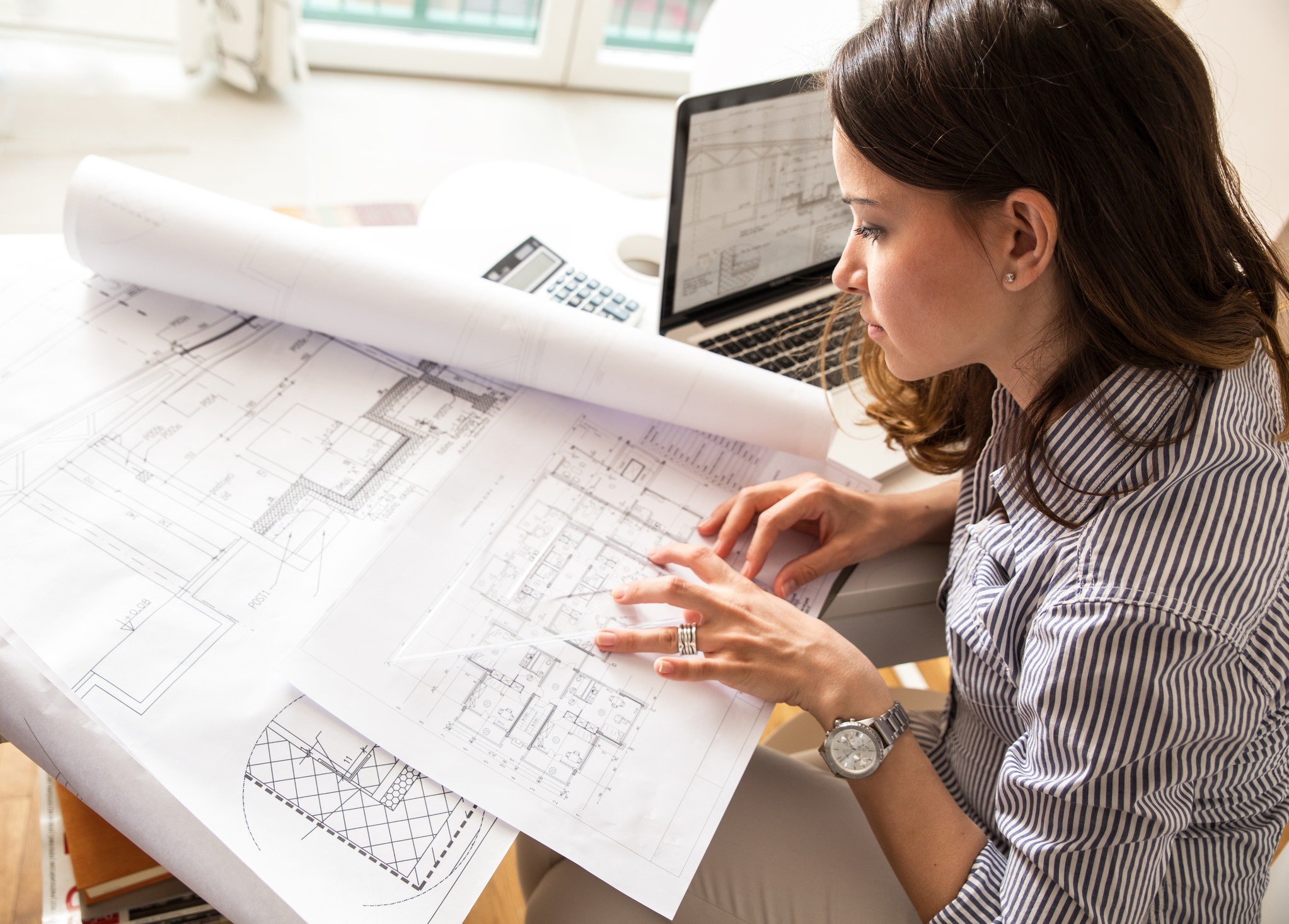 Woman looking over architectural drawings