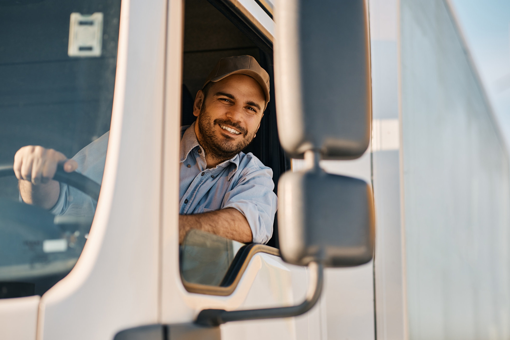 A smiling truck driver behind the wheel