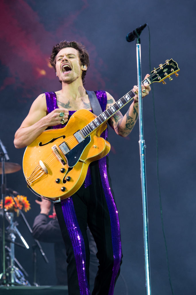 Harry Styles performing with a guittar.