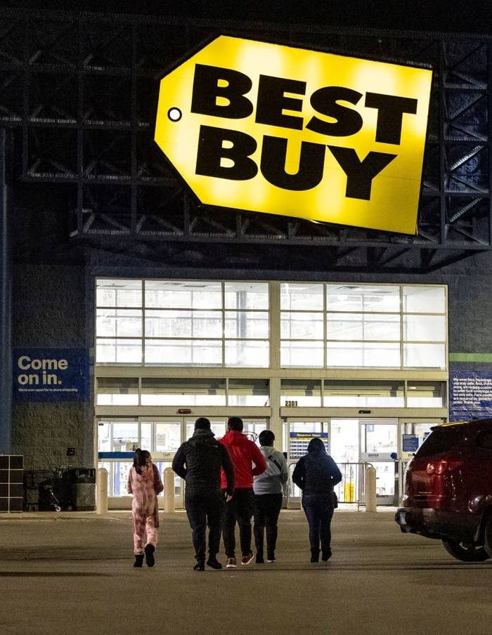 Shoppers arriving at Best Buy in the dark.