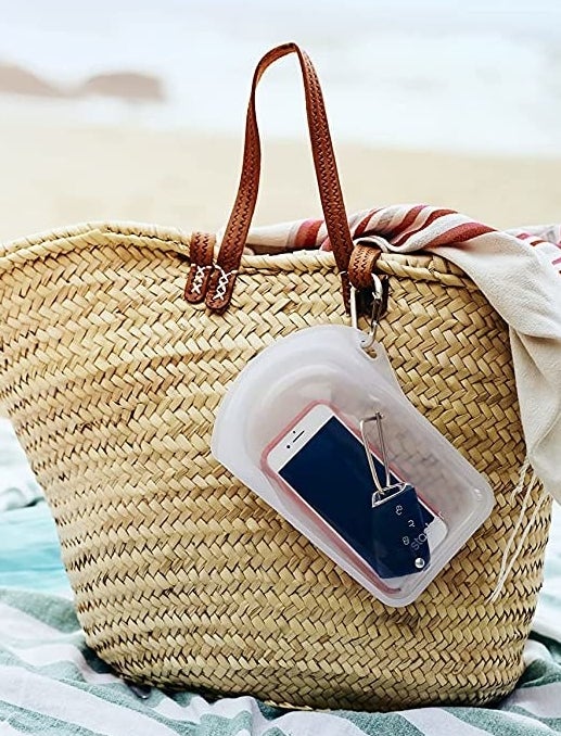 the bag with a phone on it attached to a bag on the beach